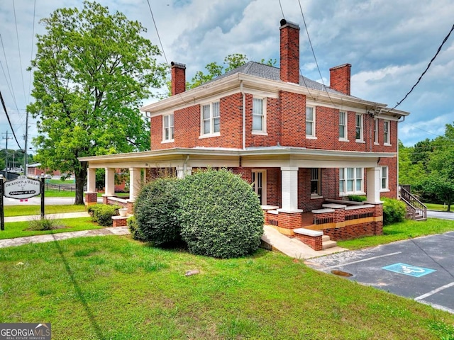 338 N Broad St, Monroe, GA 30655 - view of front of house with a chimney, brick siding, a front yard, and a porch