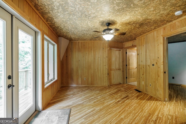 218 Wedgewood Dr, Danielsville, GA 30633 - spare room with wood walls, a ceiling fan, light wood-style flooring, an ornate ceiling, and a smoke detector