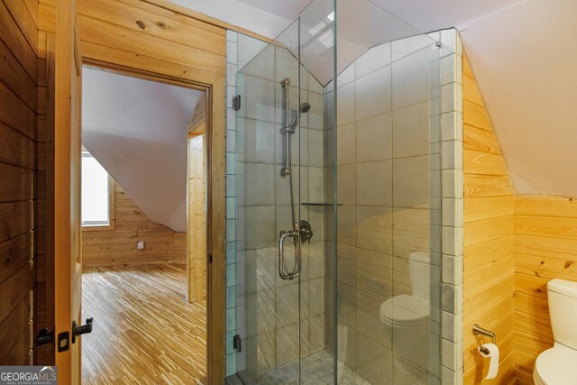 218 Wedgewood Dr, Danielsville, GA 30633 - full bathroom featuring wooden walls, wood finished floors, toilet, a stall shower, and vaulted ceiling