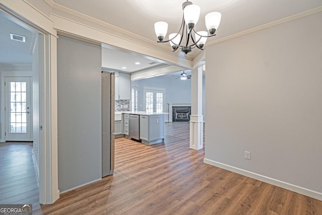 1443 Ebenezer Rd, Rincon, GA 31326 - unfurnished dining area with crown molding, a chandelier, ceiling fan, wood finished floors, and a fireplace