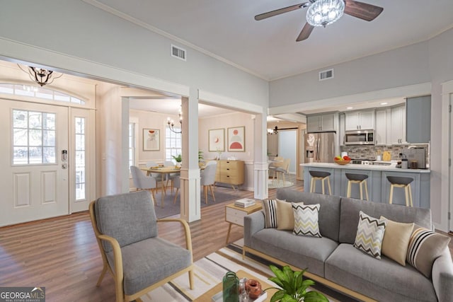 1443 Ebenezer Rd, Rincon, GA 31326 - living room featuring a chandelier, light wood-style flooring, healthy amount of natural light, crown molding, and a ceiling fan
