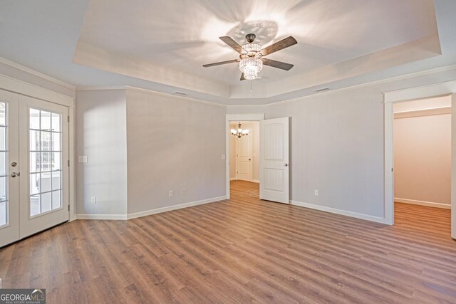 1443 Ebenezer Rd, Rincon, GA 31326 - spare room featuring a raised ceiling, wood finished floors, a chandelier, and ceiling fan