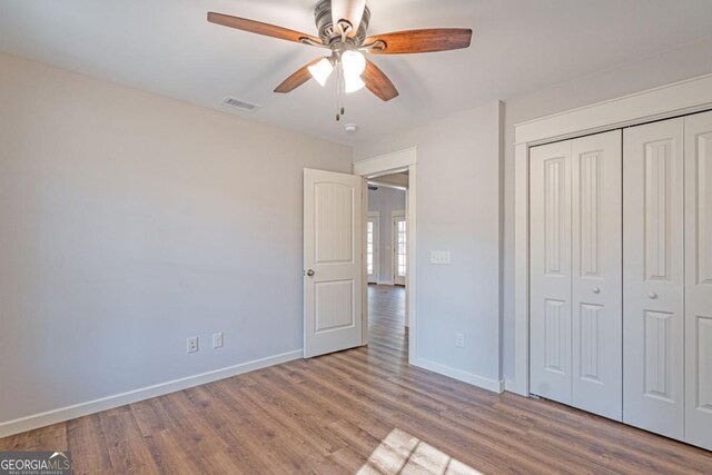 1443 Ebenezer Rd, Rincon, GA 31326 - unfurnished bedroom featuring wood finished floors, baseboards, a closet, and ceiling fan
