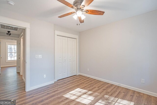 1443 Ebenezer Rd, Rincon, GA 31326 - unfurnished bedroom featuring baseboards, wood finished floors, a closet, and ceiling fan