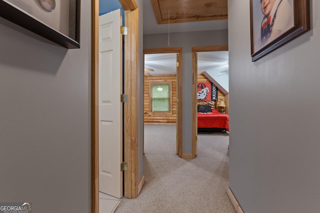 hall featuring attic access and light colored carpet