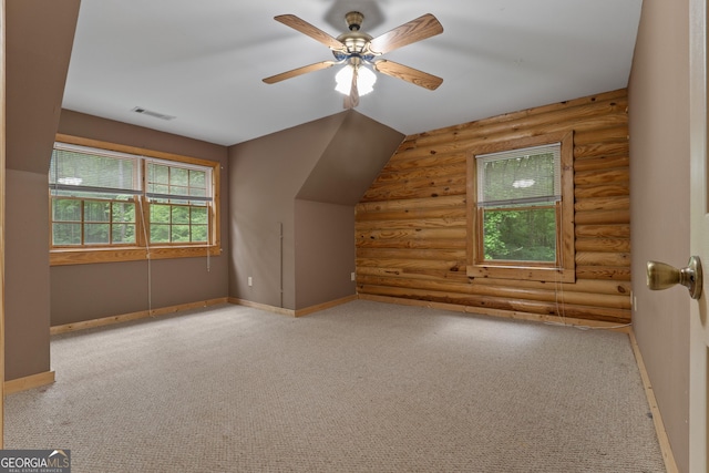additional living space featuring log walls, carpet floors, ceiling fan, and baseboards