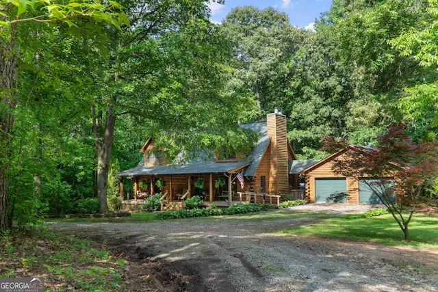 log home featuring covered porch, dirt driveway, log exterior, and a chimney
