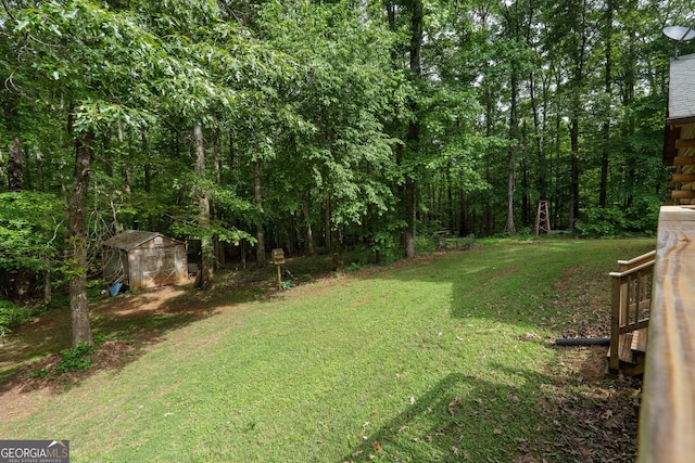 view of green lawn with a shed, an outdoor structure, and a view of trees