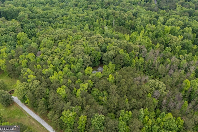 view of property location with a forest