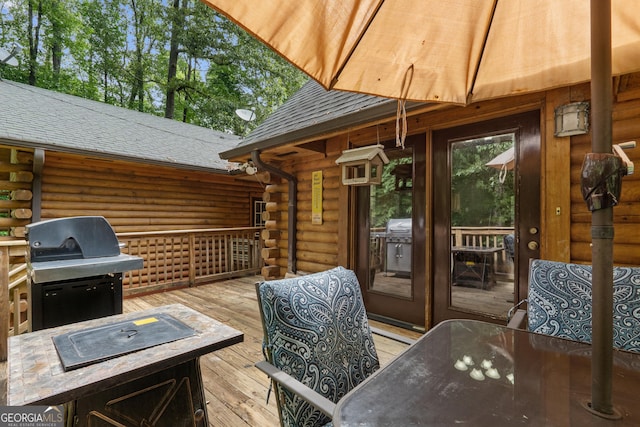 wooden deck with area for grilling, outdoor dining area, and french doors