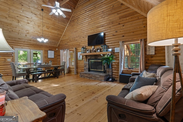living area featuring high vaulted ceiling, rustic walls, ceiling fan, a fireplace, and hardwood / wood-style floors