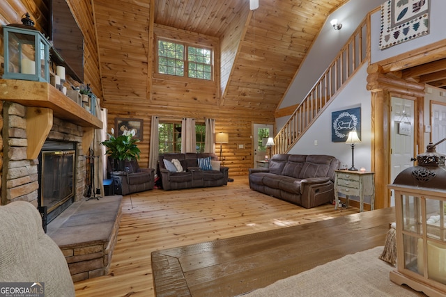 living room with high vaulted ceiling, a stone fireplace, hardwood / wood-style flooring, stairway, and wood ceiling