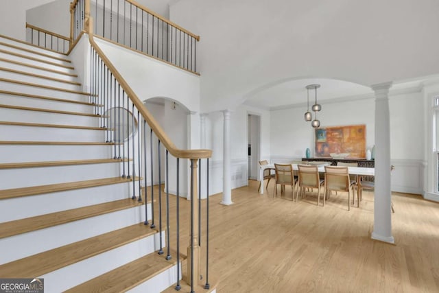 1025 Saint Marks Walk, Suwanee, GA 30024 - staircase featuring ornamental molding, arched walkways, wood finished floors, decorative columns, and wainscoting