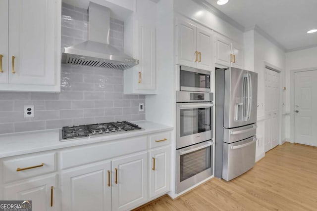 1025 Saint Marks Walk, Suwanee, GA 30024 - kitchen with stainless steel appliances, wall chimney exhaust hood, white cabinetry, crown molding, and decorative backsplash