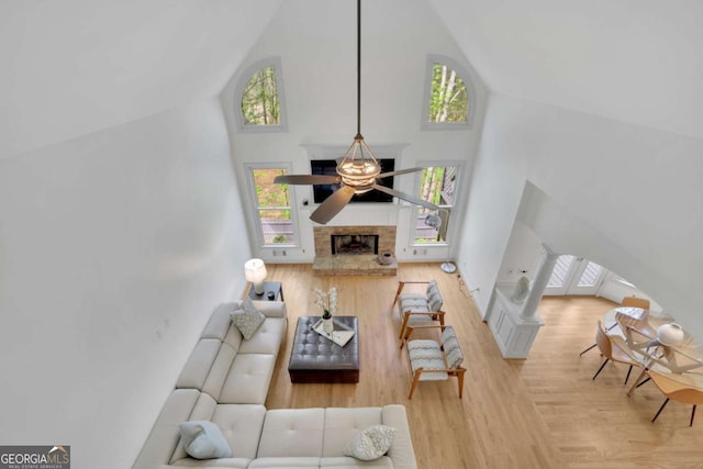 1025 Saint Marks Walk, Suwanee, GA 30024 - living room featuring high vaulted ceiling, wood finished floors, a fireplace with raised hearth, and plenty of natural light