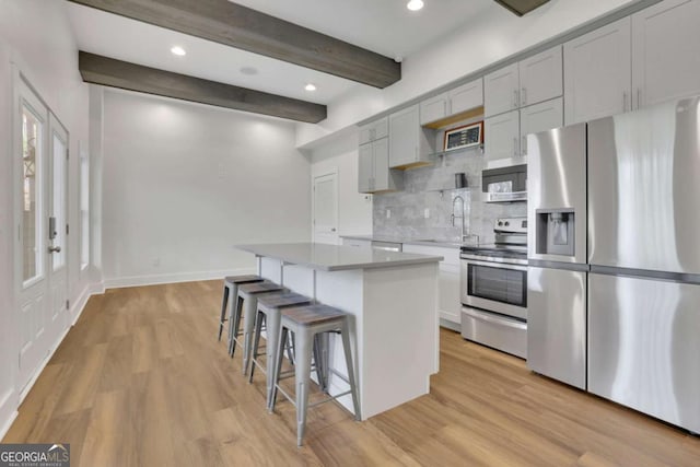 1025 Saint Marks Walk, Suwanee, GA 30024 - kitchen featuring stainless steel appliances, a sink, beamed ceiling, decorative backsplash, and a center island
