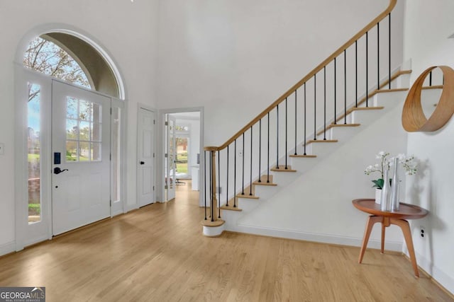 1025 Saint Marks Walk, Suwanee, GA 30024 - foyer entrance featuring wood finished floors, plenty of natural light, a high ceiling, baseboards, and stairs