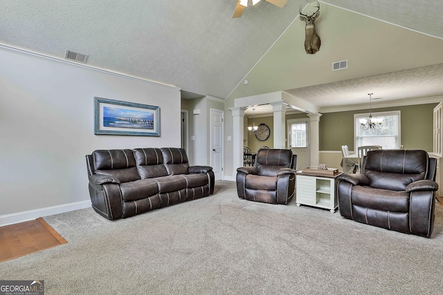 living area with ornate columns, a chandelier, carpet, vaulted ceiling, and a ceiling fan