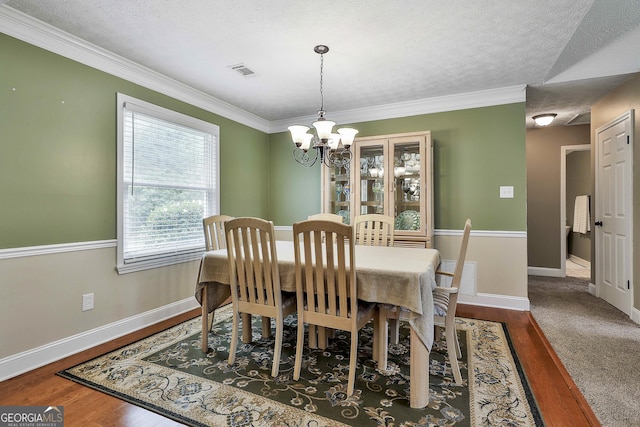 dining area featuring a chandelier, ornamental molding, baseboards, a textured ceiling, and dark wood-style floors