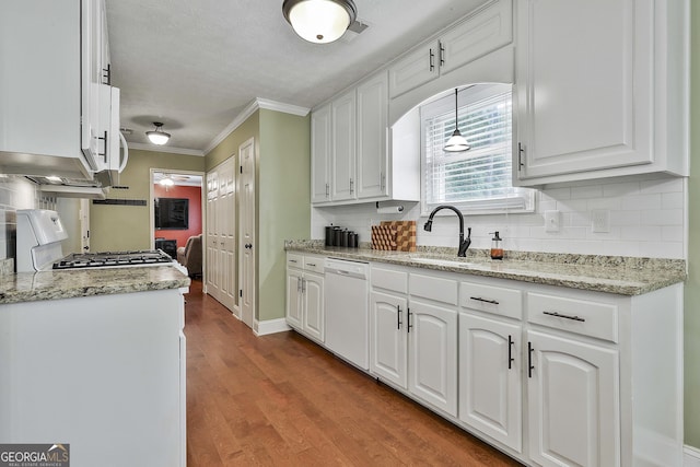 kitchen with dishwasher, stove, white cabinetry, tasteful backsplash, and crown molding