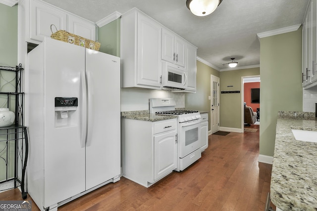 kitchen featuring white appliances, dark wood-style flooring, backsplash, white cabinetry, and crown molding