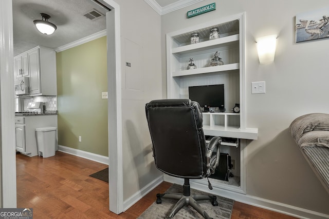 office with crown molding, wood finished floors, baseboards, and built in features