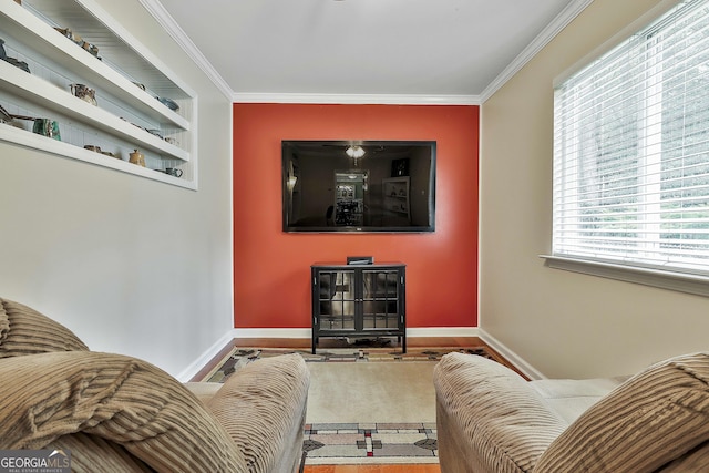 living room featuring crown molding, baseboards, and wood finished floors