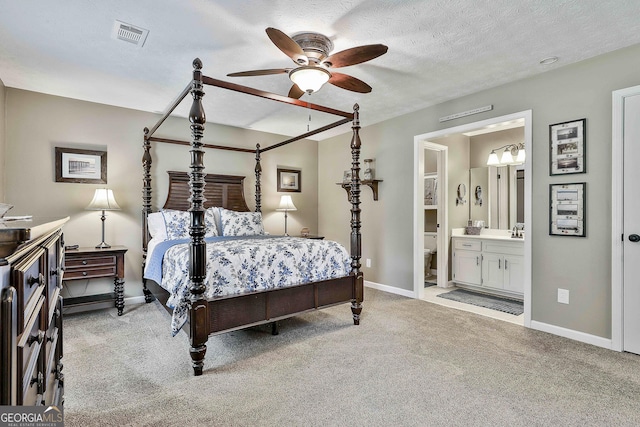bedroom with carpet, baseboards, a sink, and a textured ceiling