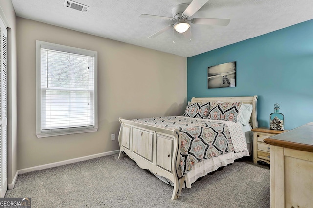 bedroom with multiple windows, carpet flooring, baseboards, a ceiling fan, and a textured ceiling