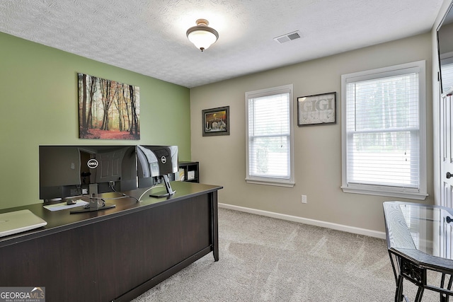 office area with light colored carpet, baseboards, and a textured ceiling