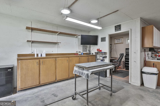 kitchen with unfinished concrete flooring, open shelves, and an office area