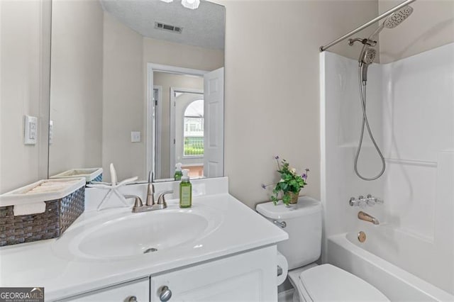 bathroom featuring toilet, vanity, and  shower combination