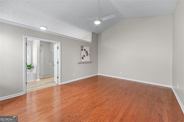 unfurnished room featuring a ceiling fan, wood finished floors, lofted ceiling, and baseboards