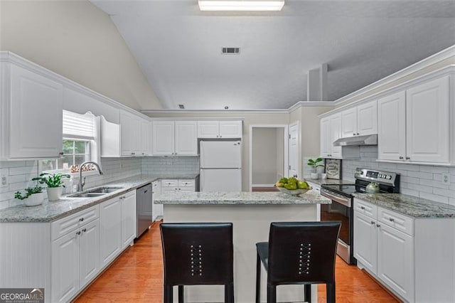 kitchen with stainless steel appliances, under cabinet range hood, a sink, a kitchen island, and white cabinets