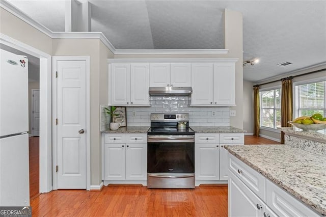 kitchen with electric range, freestanding refrigerator, under cabinet range hood, light wood-style flooring, and tasteful backsplash