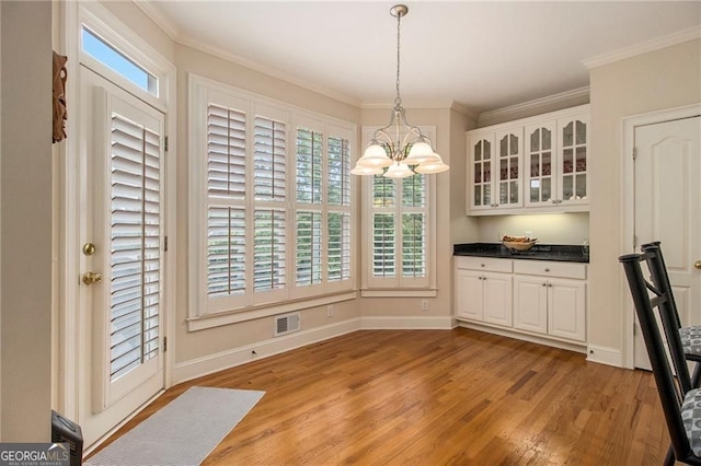 4045 Bonnett Creek Ln, Hoschton, GA 30548 - unfurnished dining area with a chandelier, light wood finished floors, ornamental molding, and baseboards