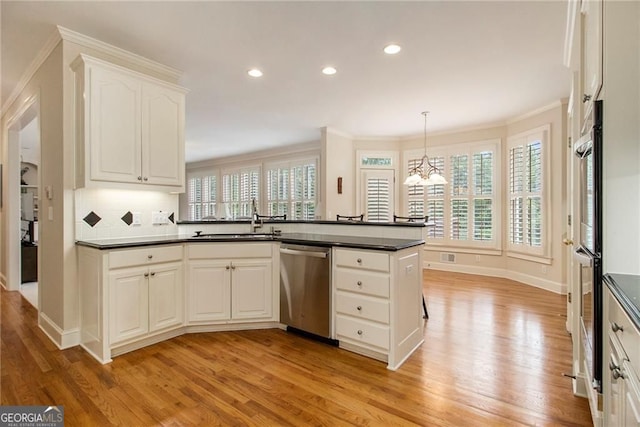 4045 Bonnett Creek Ln, Hoschton, GA 30548 - kitchen featuring stainless steel appliances, dark countertops, light wood-style flooring, a chandelier, and crown molding