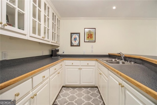 4045 Bonnett Creek Ln, Hoschton, GA 30548 - kitchen featuring a sink, white cabinets, crown molding, glass insert cabinets, and dark countertops