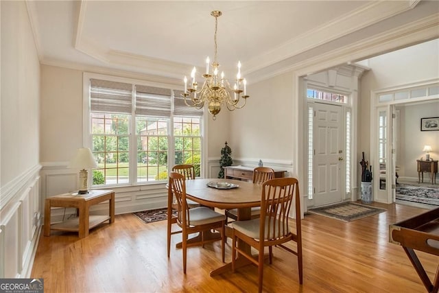 4045 Bonnett Creek Ln, Hoschton, GA 30548 - dining room with a chandelier, light wood finished floors, ornamental molding, a tray ceiling, and wainscoting