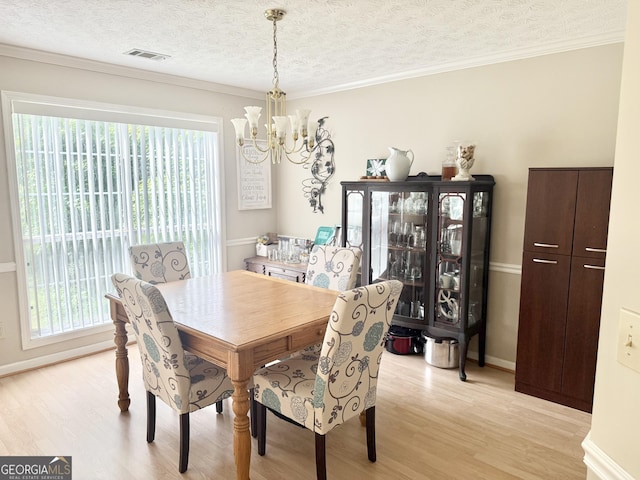 dining space featuring a chandelier, light wood-style floors, plenty of natural light, a textured ceiling, and baseboards