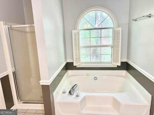 full bathroom featuring a shower stall, a garden tub, and tile patterned floors