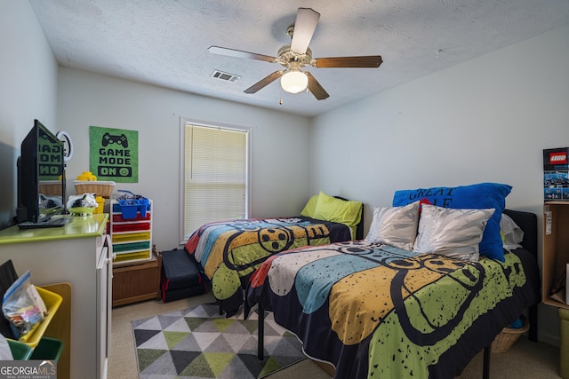 bedroom with carpet, a ceiling fan, and a textured ceiling