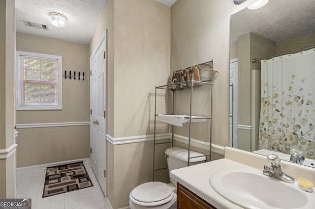 full bath with a textured ceiling, toilet, vanity, tile patterned flooring, and a shower with curtain