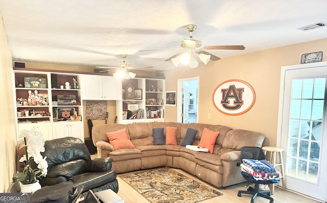 living area with a ceiling fan, light wood-style flooring, and plenty of natural light