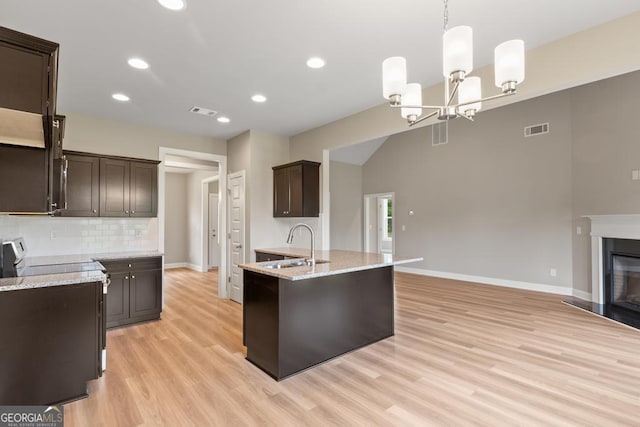 123 Oak Rd, Locust Grove, GA 30248 - kitchen with electric range, dark brown cabinetry, a sink, light wood-style floors, and tasteful backsplash