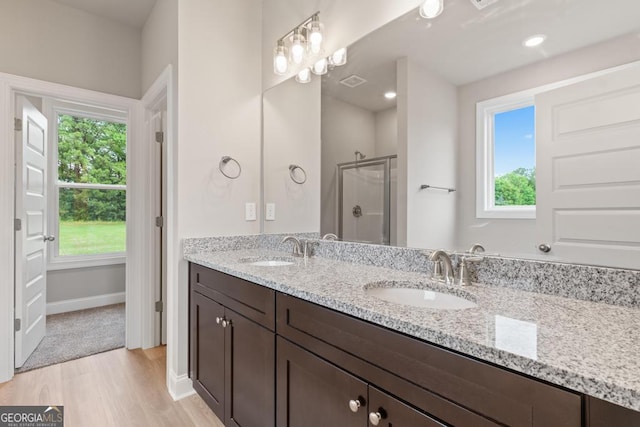 123 Oak Rd, Locust Grove, GA 30248 - bathroom with wood finished floors, a stall shower, double vanity, and baseboards