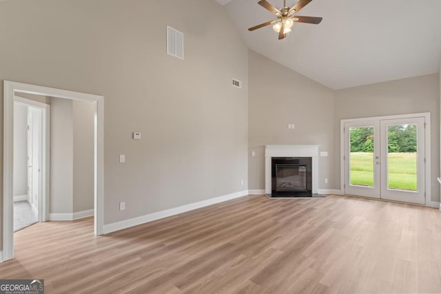 123 Oak Rd, Locust Grove, GA 30248 - unfurnished living room with high vaulted ceiling, baseboards, a ceiling fan, a fireplace with flush hearth, and light wood-style flooring