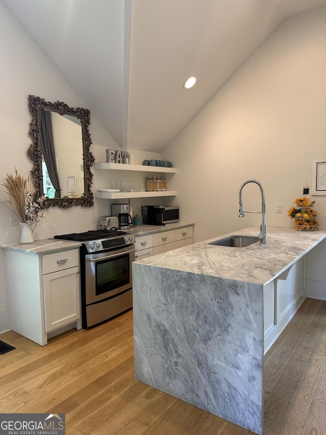 10583 Serenbe Ln, Palmetto, GA 30268 - kitchen with stainless steel appliances, vaulted ceiling, light wood-type flooring, a peninsula, and white cabinetry