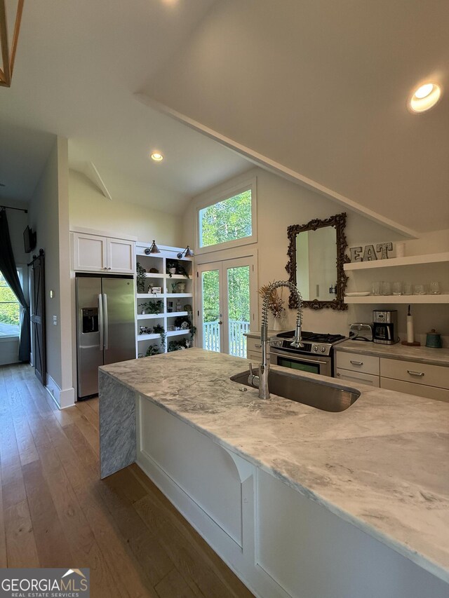 10583 Serenbe Ln, Palmetto, GA 30268 - kitchen with stainless steel refrigerator with ice dispenser, white cabinets, lofted ceiling, wood-type flooring, and recessed lighting