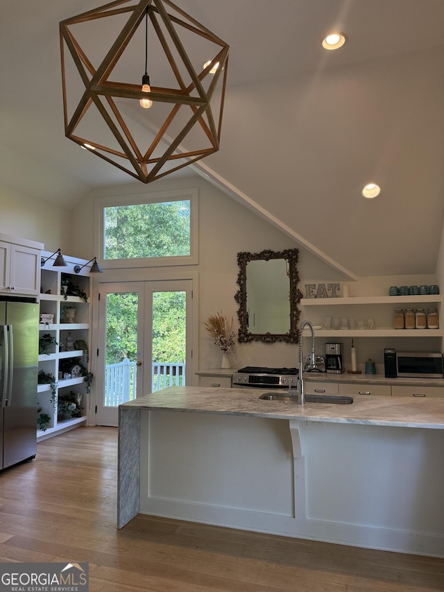 10583 Serenbe Ln, Palmetto, GA 30268 - kitchen with freestanding refrigerator, light stone counters, lofted ceiling, open shelves, and light wood-style floors